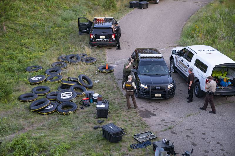 Authorities gather near the banks of Apple river in Somerset, Wisconsin, after five people were stabbed while tubing. AP