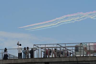 People watch a performance by Blue Impulse.