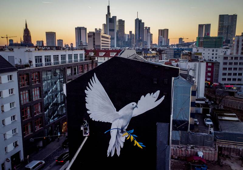 A peace mural showing a dove with a branch in Ukrainian colours by artist Justus Becker is painted on the wall of a house in Frankfurt, Germany. AP