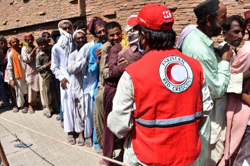 People affected by floods queue to receive food distributed by the Red Crescent Society in Larkana, Pakistan. EPA 