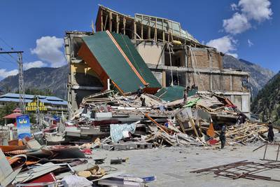 People salvage items from a damaged building in Kalam, Swat Valley. AP