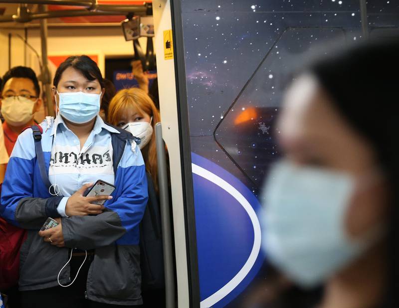 Passengers wear protective masks as they stand within a skytrain coach in Bangkok, Thailand.  EPA