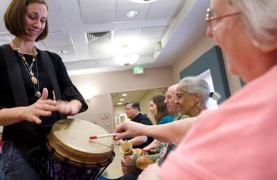 Music therapist Heather Davidson (L) plays a drum with Claire Diering (R) during a drum circle with patients with Alzheimer's disease at the Copper Ridge Care Centre in Sykesville, Maryland. AFP / Saul LOEB