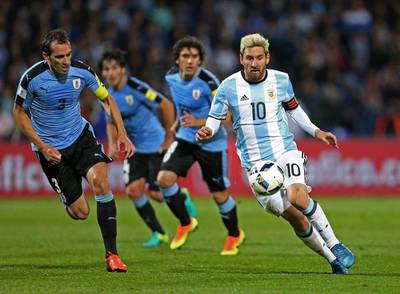 Argentina's Lionel Messi, right, vies for the ball with Uruguay's Diego Godin. Nicolas Aguilera / EPA