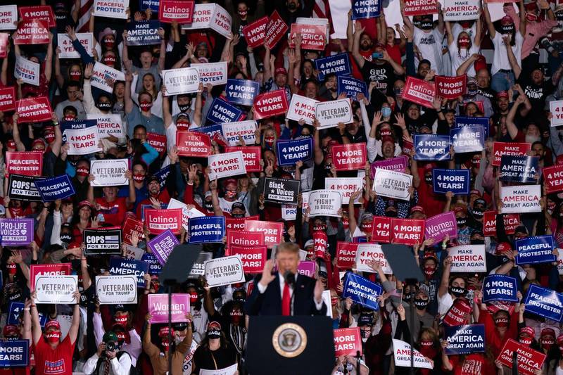 Attendees cheer and hold up signs as US President Donald Trump speaks at a campaign rally in Macon, Georgia. AFP