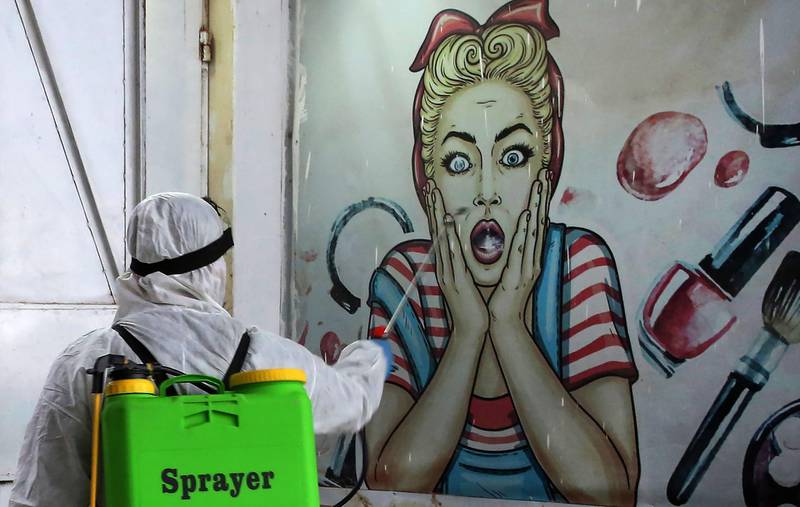 A volunteer disinfects a shop in Baghdad's Bayaa neighbourhood.   AFP