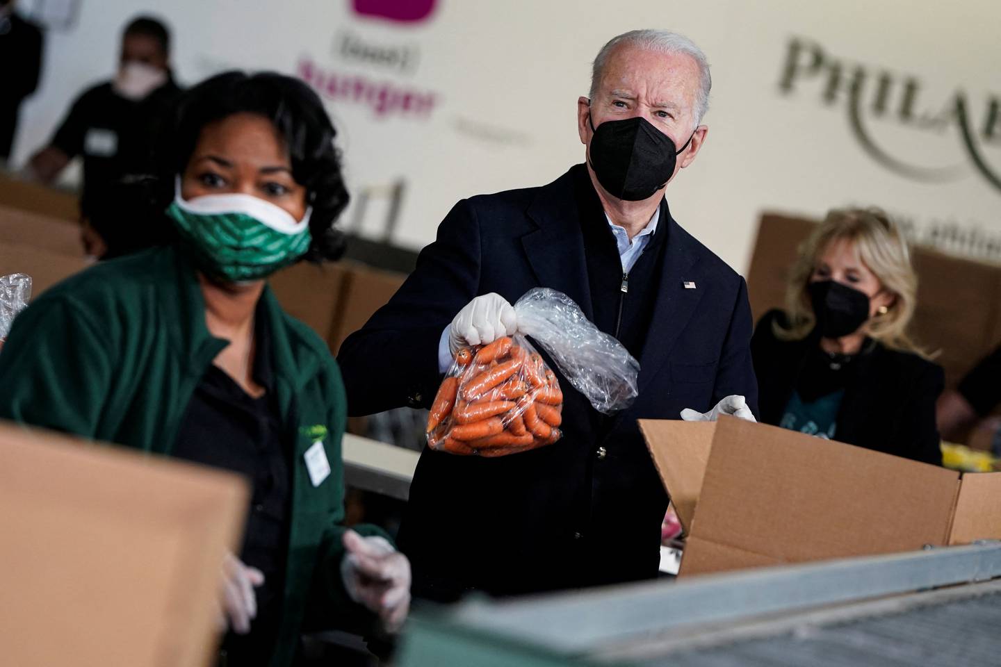 US President Joe Biden puts a bag of carrots into a box at Philabundance, a hunger relief organisation in Philadelphia, US, on January 16. Reuters