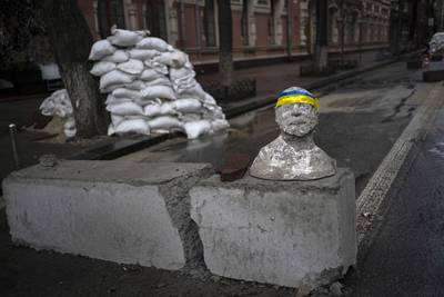 A bust adorned with a headband in the colours of the Ukraine flag at a checkpoint in Kyiv, Ukraine. AP
