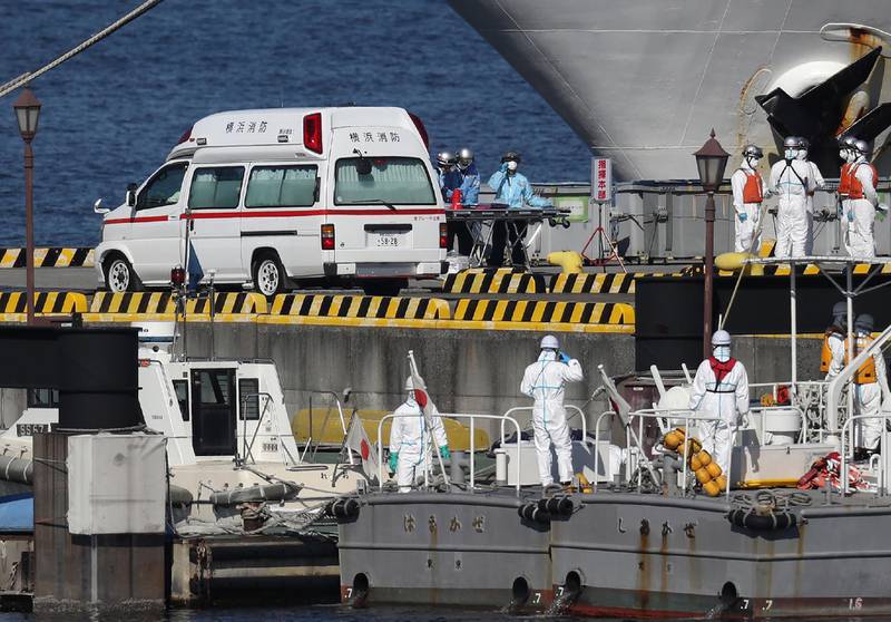Workers in protective gear are seen next to a waiting ambulance at the Japan Coast Guard base in Yokohama.  AFP