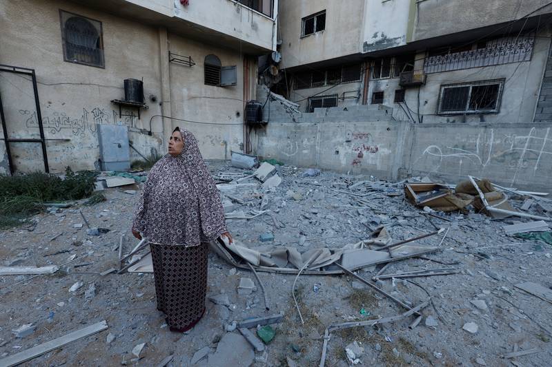 A woman walks through a Gaza neighbourhood where Tayseer Al Jabari, a senior commander of Islamic Jihad militant group, was killed by Israeli strikes. Reuters