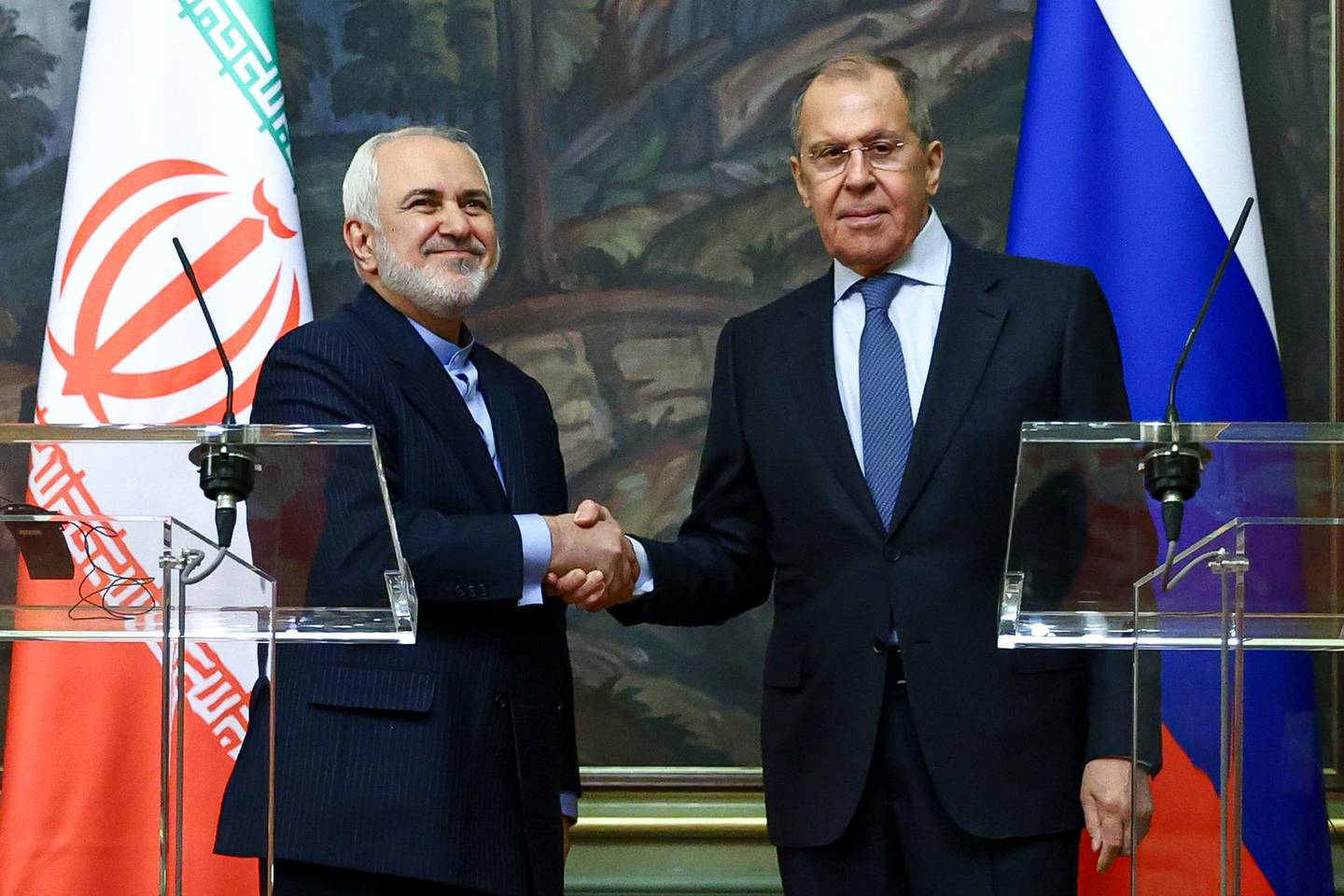 In this handout photo released by Russian Foreign Ministry Press Service, Russian Foreign Minister Sergey Lavrov, right, and Iranian Foreign Minister Mohammad Javad Zarif shake hands after their joint news conference following the talks in Moscow, Russia, Tuesday, Jan. 26, 2021. (Russian Foreign Ministry Press Service via AP)