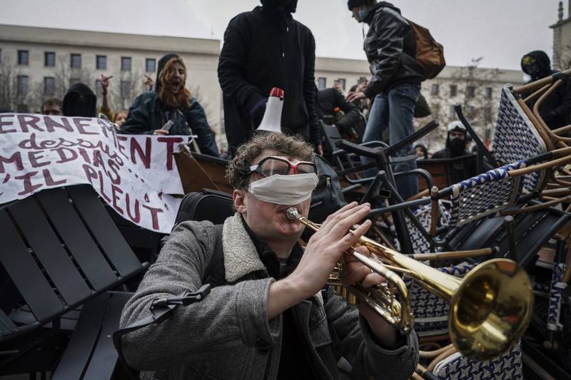 A man plays the trumpet in front of a barricade during a demonstration in Lyon, France, on Tuesday, March 7, 2023.  AP Photo
