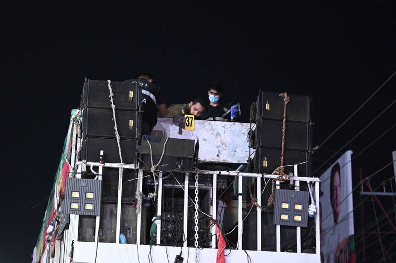 Investigators examine the rooftop of a container truck used by the former Pakistani prime minister Imran Khan during his political rallies, hours after a gun attack in Wazirabad. AFP