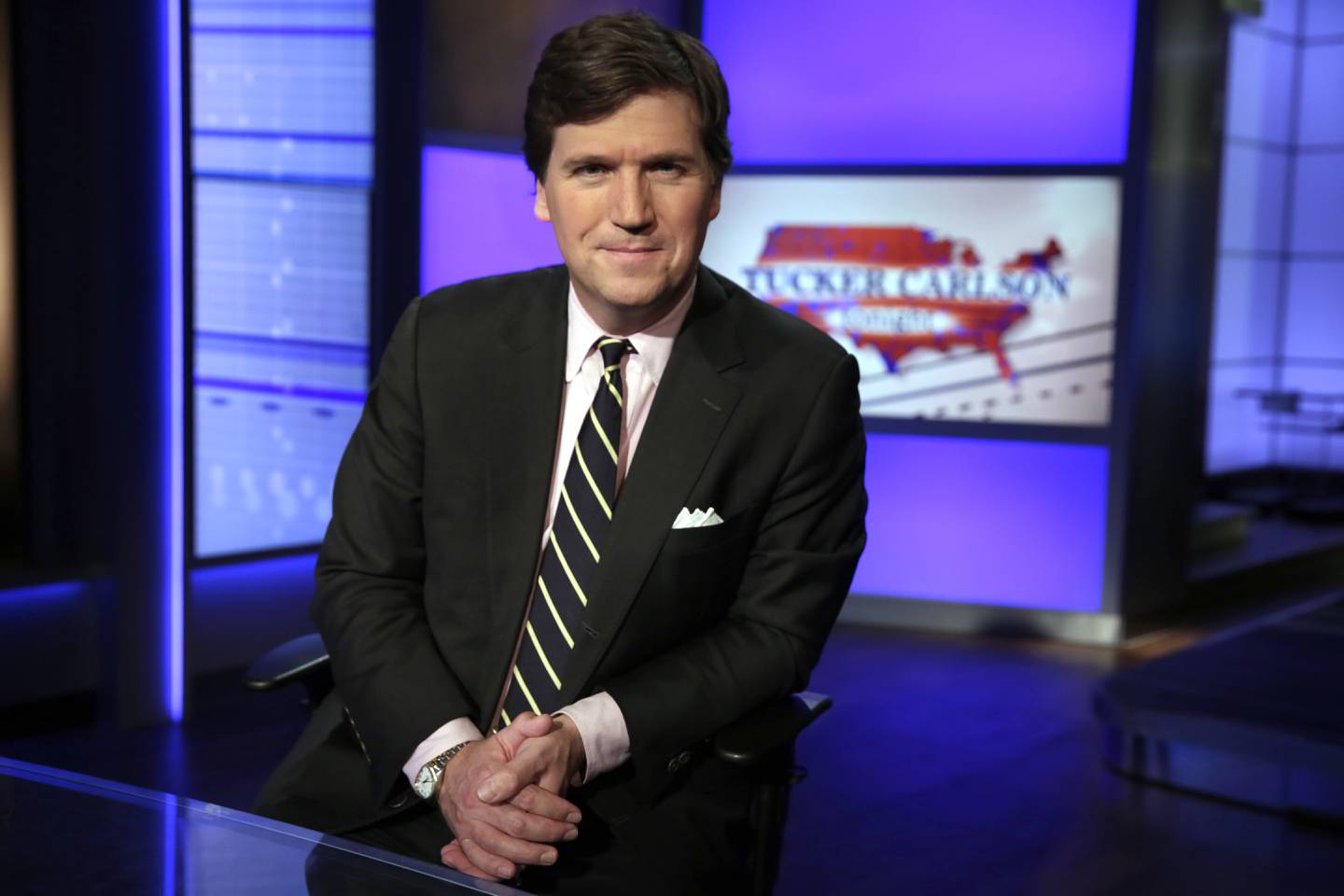 Tucker Carlson, host of "Tucker Carlson Tonight," poses for photos in a Fox News Channel studio in New York. AP
