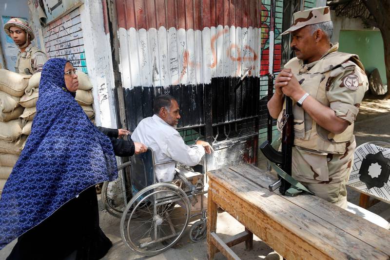 Army officers secure a polling station as people enter to vote on constitutional amendments on the second day of a nationwide referendum in Cairo, Egypt, Sunday April 21, 2019. Egyptians are voting on constitutional amendments that would allow el-Sissi to stay in power until 2030. (AP Photo/Amr Nabil)