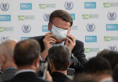 Brazil's President Jair Bolsonaro puts on a mask during the inauguration of the new General Abreu civic-military school in Rio de Janeiro, Brazil, on August 14, 2020. AP Photo