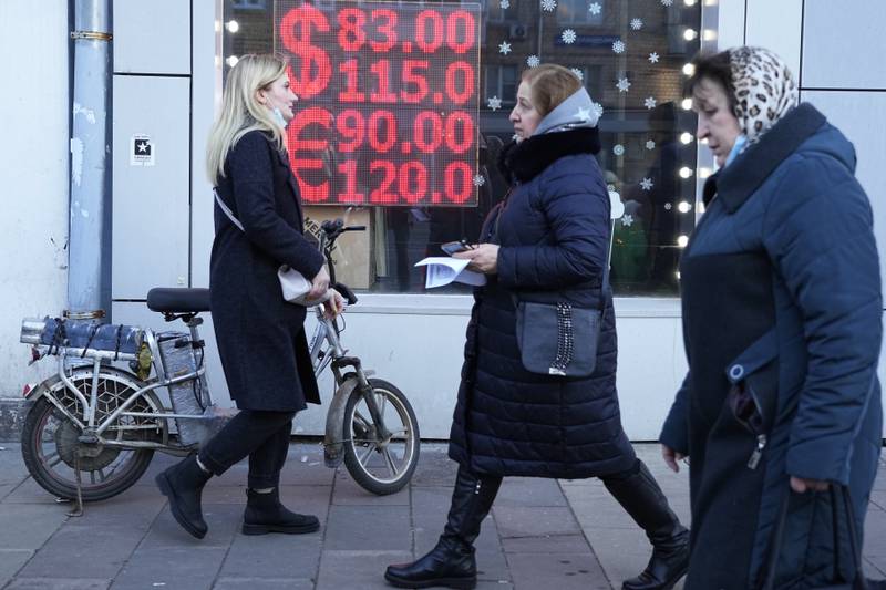 People walk past a currency exchange in Moscow. Ordinary Russians are facing the prospect of higher prices amid a plummeting rouble. AP Photo