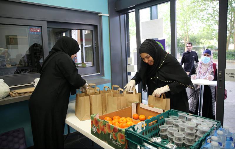 LONDON, UNITED KINGDOM - MAY 09: (left to right) Volunteers Samira and Fateha Miah organise the Ã¢takeaway iftarÃ¢ meal from the QueenÃ¢s Crescent Community Centre (QCCA) at a pop-up facility open for both Muslims and non-Muslims as part of their Iftar for All project in north London, United Kingdom on May 09, 2020. Today over a hundred meals were given out by the QCCA to those in need. Recipients of the meals varied in both age and backgrounds from vulnerable elderly locals to young families. The idea came up whilst Mr MiahÃ¢s fell ill after contracting covid-19 and raised thousands to fund a food bank for the most vulnerable in the community. (Photo by Isabel Infantes/Anadolu Agency via Getty Images)