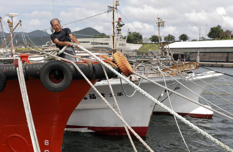 A fisherman tighten a rope to anchor his fishing boat with his colleague's boats in preparation for powerful typhoon Haishen in Makurazaki, Kagoshima Prefecture, southwestern Japan.  EPA