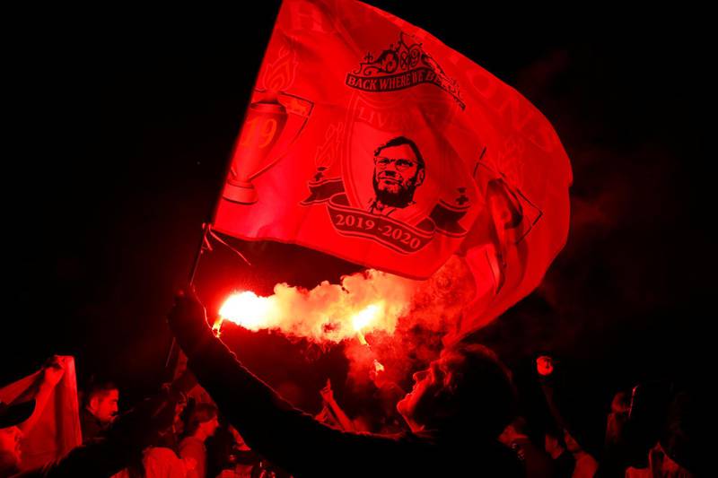 Liverpool fans celebrate with flares outside the stadium. Reuters