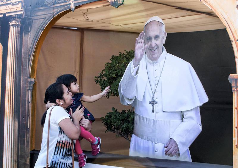 DUBAI, UNITED ARAB EMIRATES -A girl reaching out for the Pope image at St. Mary's Catholic Church, Oud Mehta.  Leslie Pableo for The National for Anam Rizvi's story