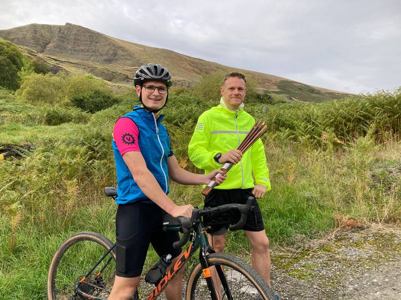 Tom Kingston hands over the Cop27 relay baton to Huw Selly in the Derbyshire Peak District. The National