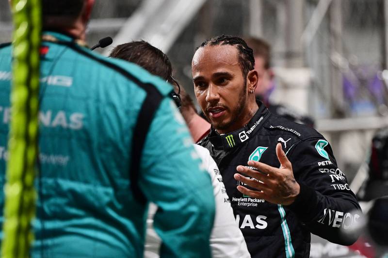 Lewis Hamilton speaks with team members during a second stop in the race. AFP