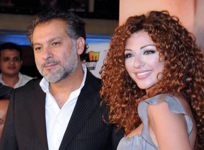Lebanese actress and singer Myriam Fares arrives with Syrian director Hatem Ali to a special screening of their new film "Silina" at a movie theatre in the Egyptian capital Cairo late on May 13, 2009. The musical film is based on an operetta, titled "Hala wal Malek" (Hala and the King), which was first presented in 1967 by Lebanese diva Fairuz and the Rahbani Brothers. AFP PHOTO/AMR AHMAD (Photo by AMR AHMAD / AFP)