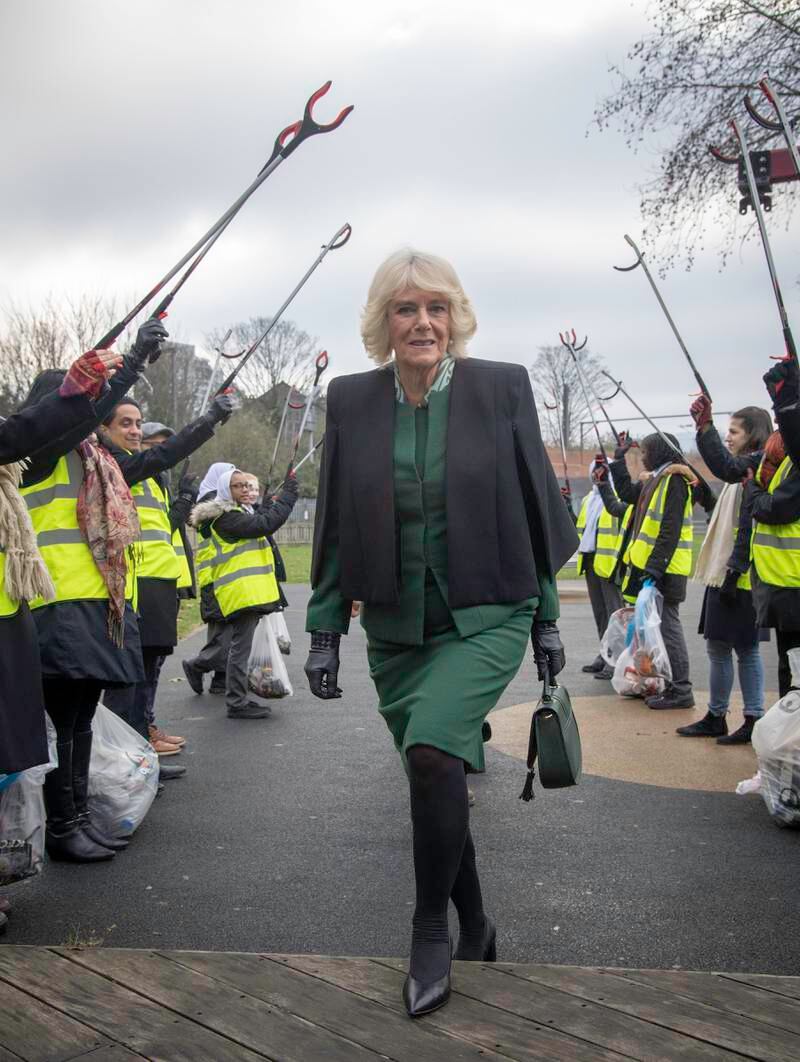Camilla, in a green dress and black cape, is greeted by a Guard of Honour during her visit to the Malmesbury Residents Association on January 23, 2019 in London. Getty Images