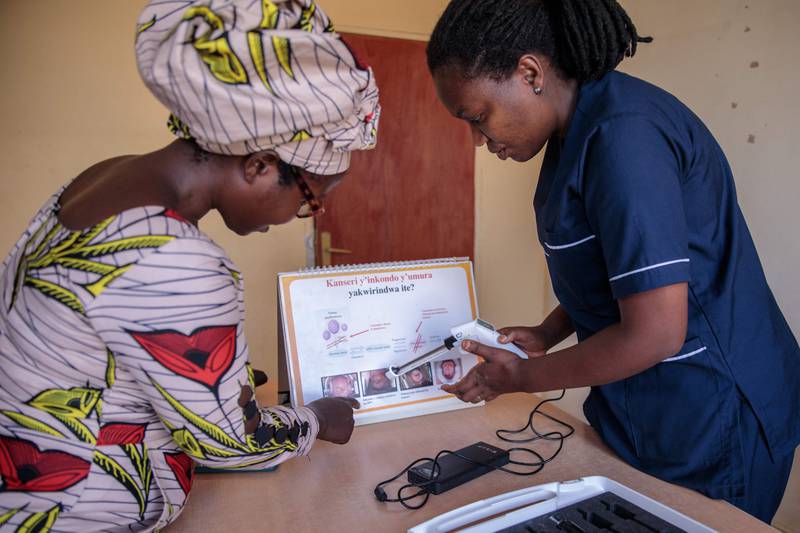 Rwandan midwife Christine Musabyeyezu (R) speaks to a patient about a thermal coagulator, a cost-effective alternative to cryotherapy, the traditional technology used in the treatment of cervical cancer, at Remera Health Centre in Kigali on March 7. AFP