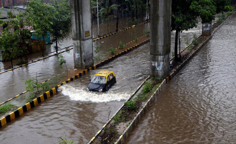 A car moves through a waterlogged street following heavy rains in Mumbai. AP Photo