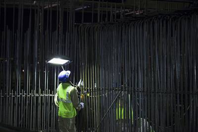 A worker checks steel rods during his night shift. Casting steel at night also improves casting conditions because during the day the reinforcing steels can reach 60-70C. This has an adverse effect on the bond between the concrete and the steel, the proper bonding of which is essential for reinforced concrete of the type in use at the Louvre AD. Silvia Razgova / The National