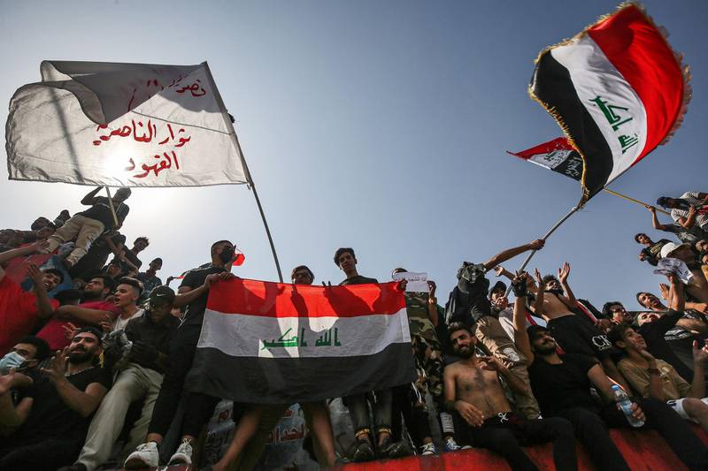 Protesters wave Iraqi national flags as they gather for a demonstration in Tahrir Square in the centre of Iraq's capital Baghdad. AFP