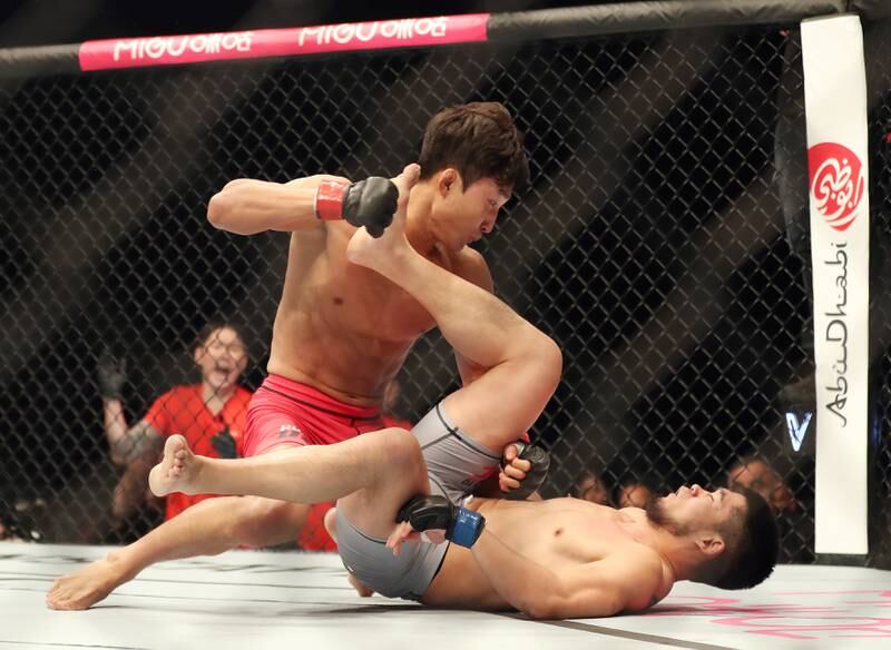 Lee Jeong-Yeong, red, takes on Lu Kai in a featherweight bout of Road to UFC in Abu Dhabi. Chris Whiteoak / The National