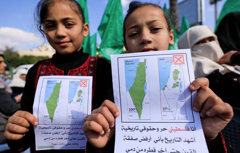 Young Palestinian girls hold petitions with a map of British mandate Palestine (L) and a current map of the Palestinian territories without Israeli-annexed areas and settlements, as they take part in a demonstration by women supporters of the Hamas movement against the US President Donald Trump plan for Middle East, in Gaza City on February 5, 2020. / AFP / Emmanuel DUNAND
