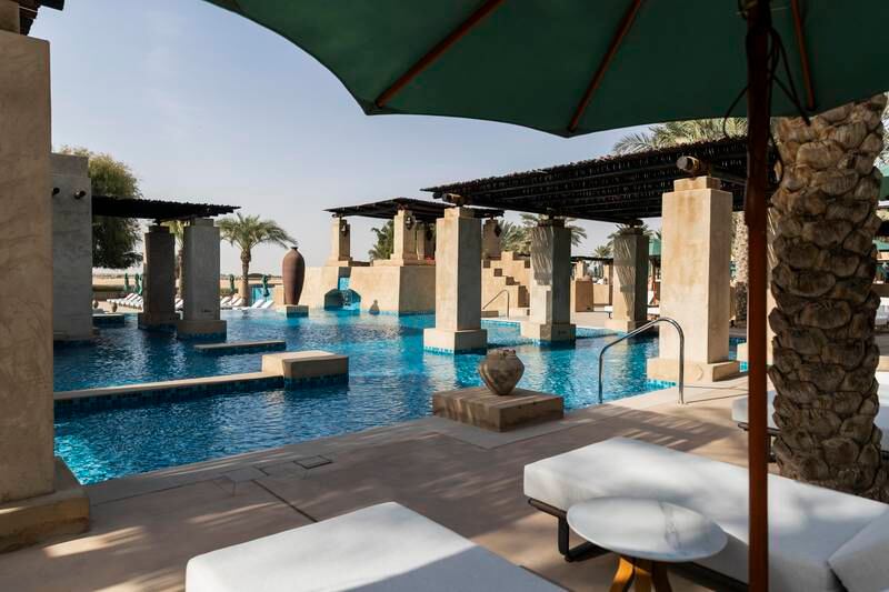 The renovated pool is surrounded by sun loungers and cabanas and has a swim-up bar

