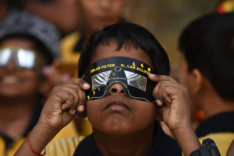 A schoolboy uses solar filter glasses to view a rare 'ring of fire' solar eclipse at a school in Mumbai. AFP