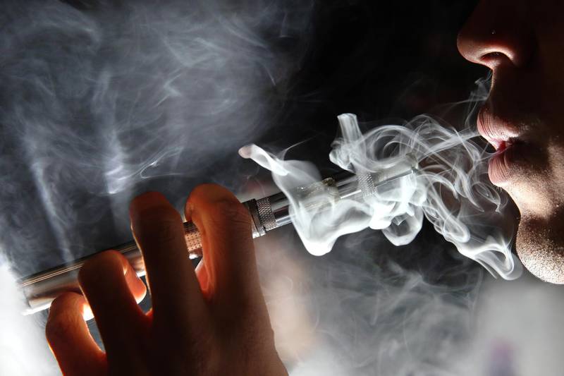 LONDON, ENGLAND - AUGUST 27:  In this photo illustration, a man smokes an E-Cigarette at the V-Revolution E-Cigarette shop in Covent Garden on August 27, 2014 in London, England. The Department of Health have ruled out the outlawing of 'e-cigs' in enclosed spaces in England, despite calls by WHO, The World Health Organisation to do so. WHO have recommended a ban on indoor smoking of e-cigs as part of tougher regulation of products dangerous to children.  (Photo by Dan Kitwood/Getty Images)