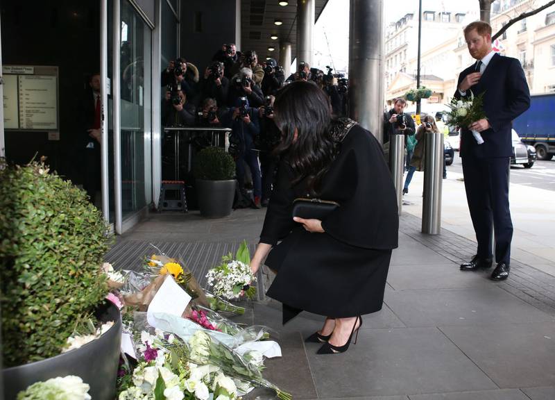 Meghan spent some time reading messages left on floral tributes outside the Commission. AFP