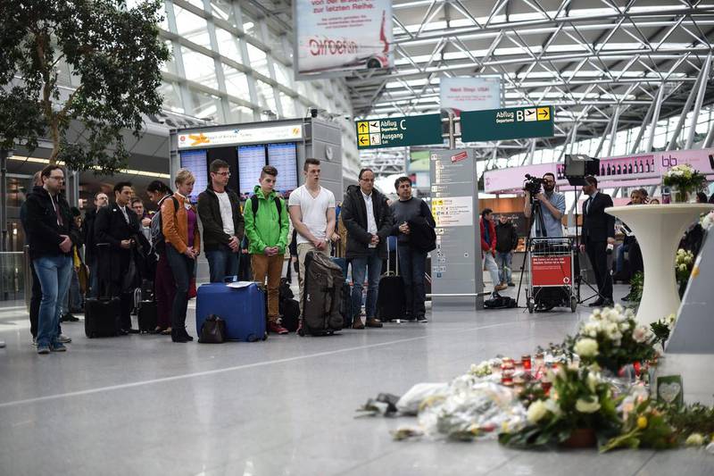 Visitors and travelers stand in a moment of silence on March 26, 2015 at a memorial desk set up in commemoration of the victims of the Germanwings plane crash at the airport in Duesseldorf where the jet was due to land. Maja Hitij/EPA