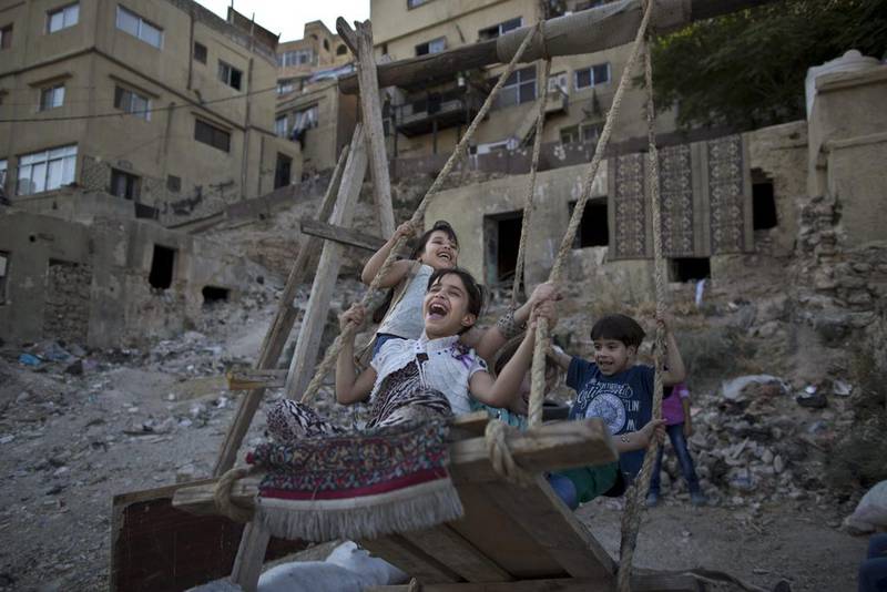 Children enjoy a ride on a makeshift swing during Eid Al Fitr in Amman. AP photo
