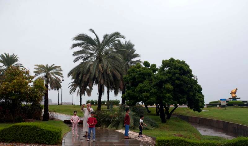 People take pictures near damaged trees after Shaheen hit Muscat. EPA