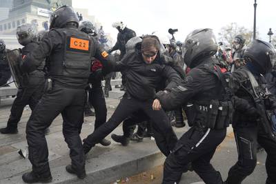 A protester is detained by police during a demonstration in Paris. AP