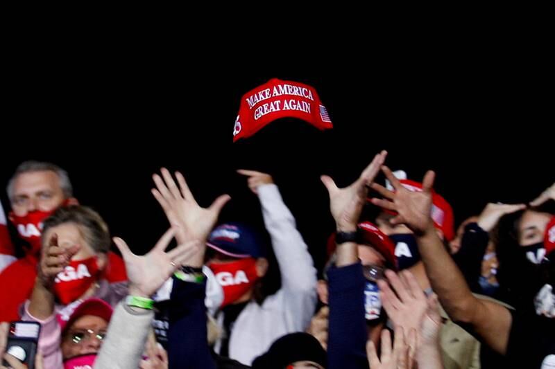 US President Donald Trump supporters try to catch a hat during a campaign event in Fayetteville, North Carolina, on September 19, 2020. Reuters