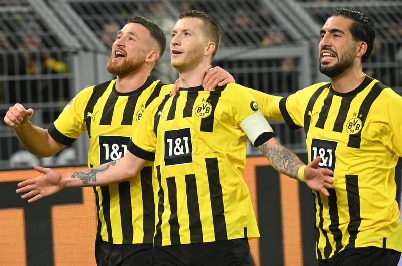 Marco Reus, centre, celebrates with Salih Ozcan, left, and Emre Can scoring a penalty to give Borussia Dortmund the lead. AFP