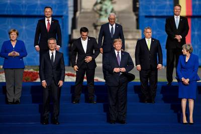 TOPSHOT - US President Donald Trump poses with Germany's Chancellor Angela Merkel (L), NATO Secretary General Jens Stoltenberg (3R), Britain's Prime Minister Theresa May (R) in a group photograph ahead of a working dinner at The Parc du Cinquantenaire - Jubelpark Park in Brussels on July 11, 2018, during the North Atlantic Treaty Organization (NATO) summit.  / AFP / Brendan Smialowski

