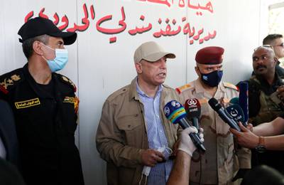 Iraqi Prime Minister Mustafa al-Kadhimi, center, speaks to the journalists as he stands with Lt. Gen. Abdul-Wahab al-Saadi, the counterterrorism forces commander, left, at thw Iraq-Iran border crossing of Mandali in northern province of Diyala, Iraq, Saturday, July, 11, 2020. Al-Kadhimi launched a campaign in the northern province of Diyala to enforce the proper payment of taxes on imported goods and recover "hundreds of millions of dollars" in revenues lost to bribery and other illicit practices. Security forces from the Interior Ministry would supervise the work of border guards in the first step of the campaign in the Mandili border crossing, he told reporters. (Thaier al-Sudani/Pool Photo via AP)