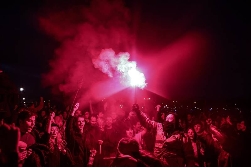 Protesters light flares near the National Assembly in Paris after the government pushed through its pension reforms without a vote on March 16. EPA