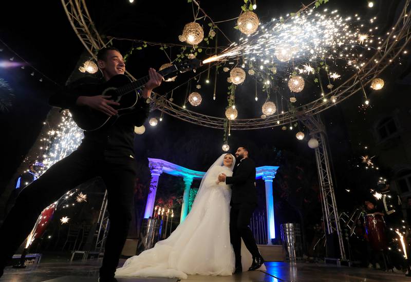 Groom Moustafa Khaled and bride Hager Yasser dance as a live band performs, during their traditional wedding celebration at the outdoor Grand Palace villa in Queisna, as Egyptian government only allows outdoor events amid the coronavirus disease (COVID-19) pandemic, in Egypt's northern Nile Delta province of Menoufia, Egypt November 4, 2020. REUTERS/Amr Abdallah Dalsh