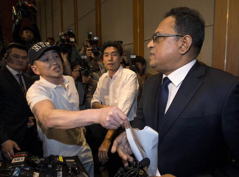 A relative of a victim complains to Ata Safdar, head of British firm Reckitt Benckiser Korea, right, during a press conference in Seoul. Yun Dong-jin / Yonhap via AP